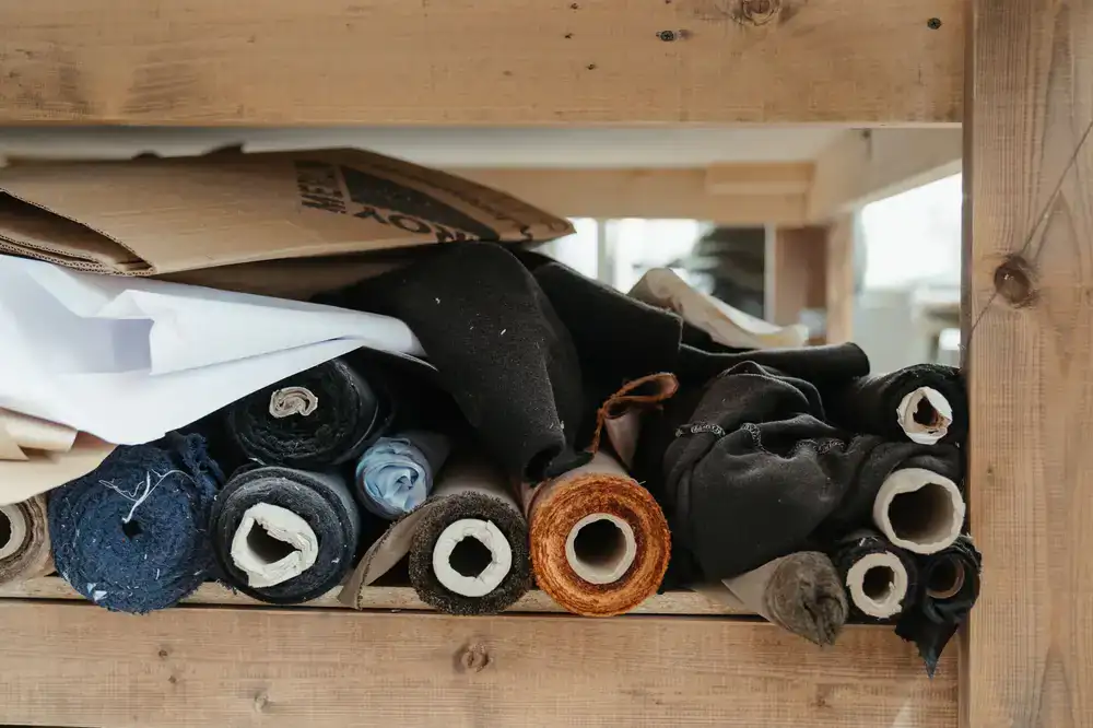 An organized upholstery workspace with tools and fabric rolls