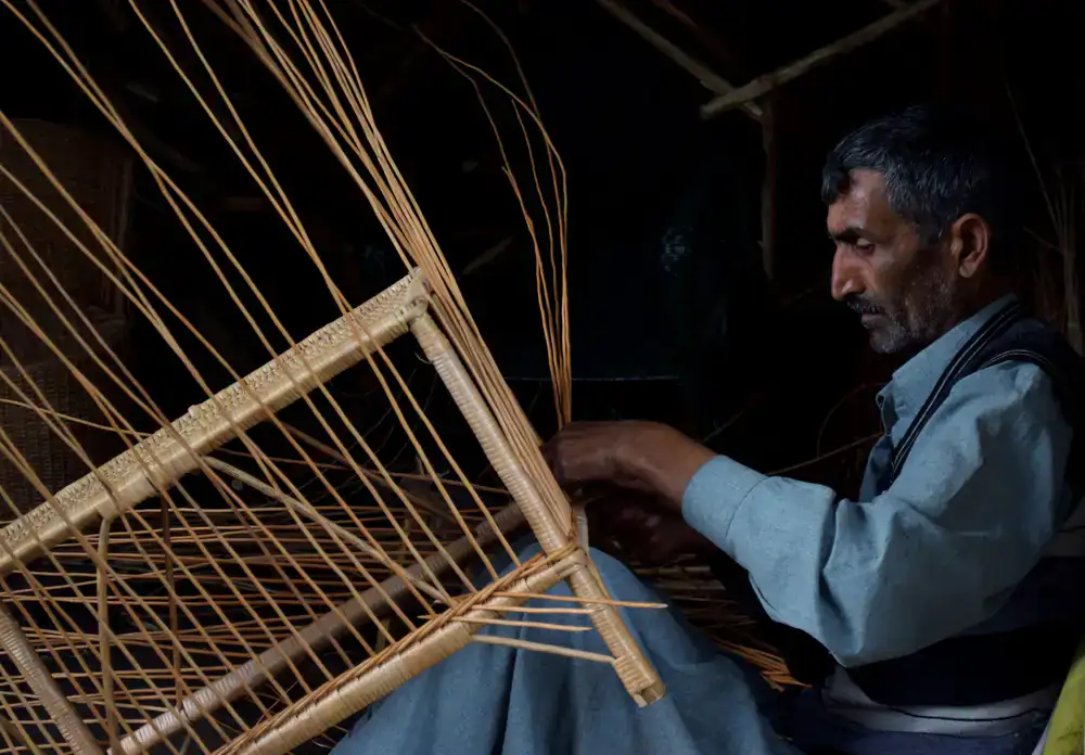Craftsman tying springs on a traditional chair seat
